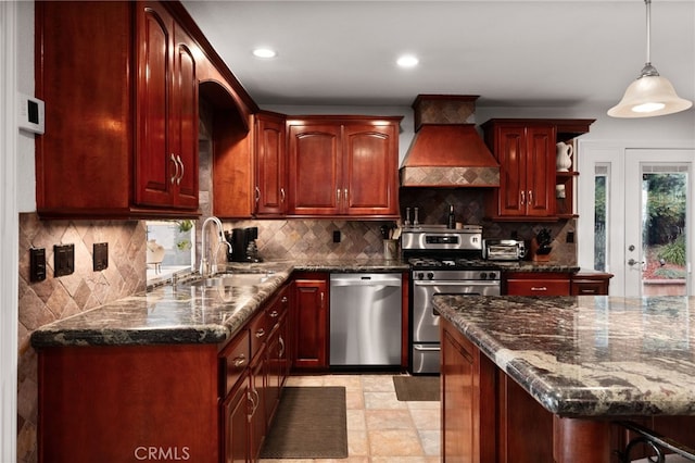 kitchen featuring stainless steel appliances, decorative backsplash, a sink, and custom range hood