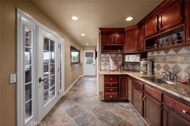 kitchen with white microwave, tasteful backsplash, open shelves, and a sink