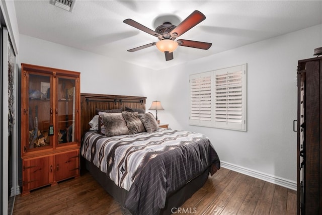 bedroom featuring a ceiling fan, visible vents, baseboards, and hardwood / wood-style flooring