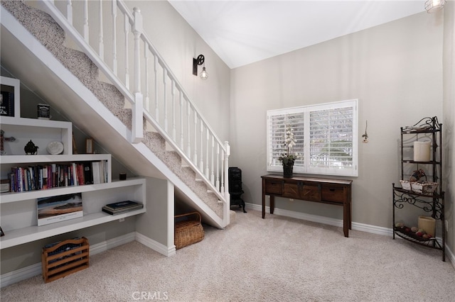 staircase featuring vaulted ceiling, carpet, and baseboards