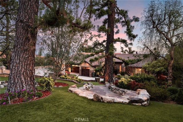 yard at dusk with an attached garage