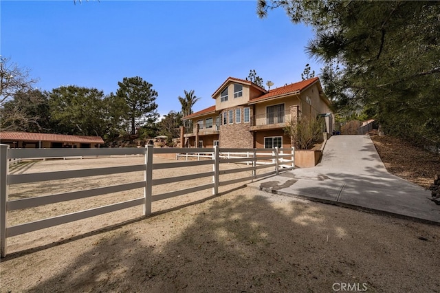 view of front of home with a tiled roof, fence, and stucco siding