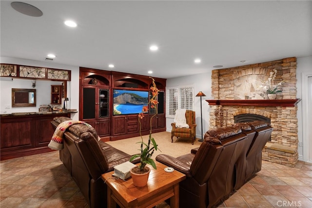 living room featuring a stone fireplace and recessed lighting