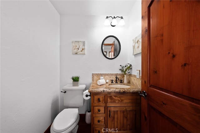 half bathroom featuring vanity and toilet