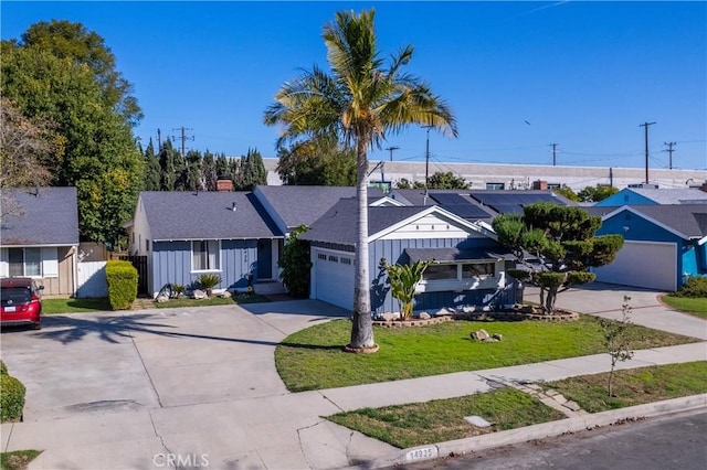 single story home with concrete driveway, a residential view, an attached garage, a front lawn, and board and batten siding