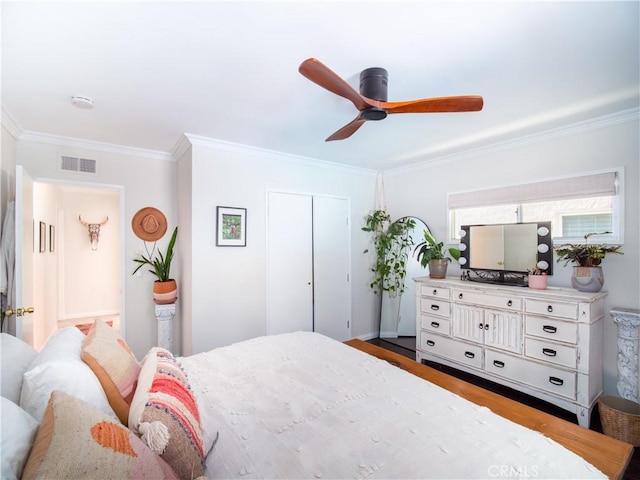 bedroom featuring a ceiling fan, visible vents, crown molding, and wood finished floors