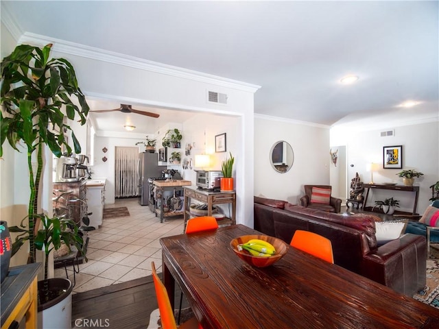 dining space with light tile patterned floors, visible vents, and crown molding