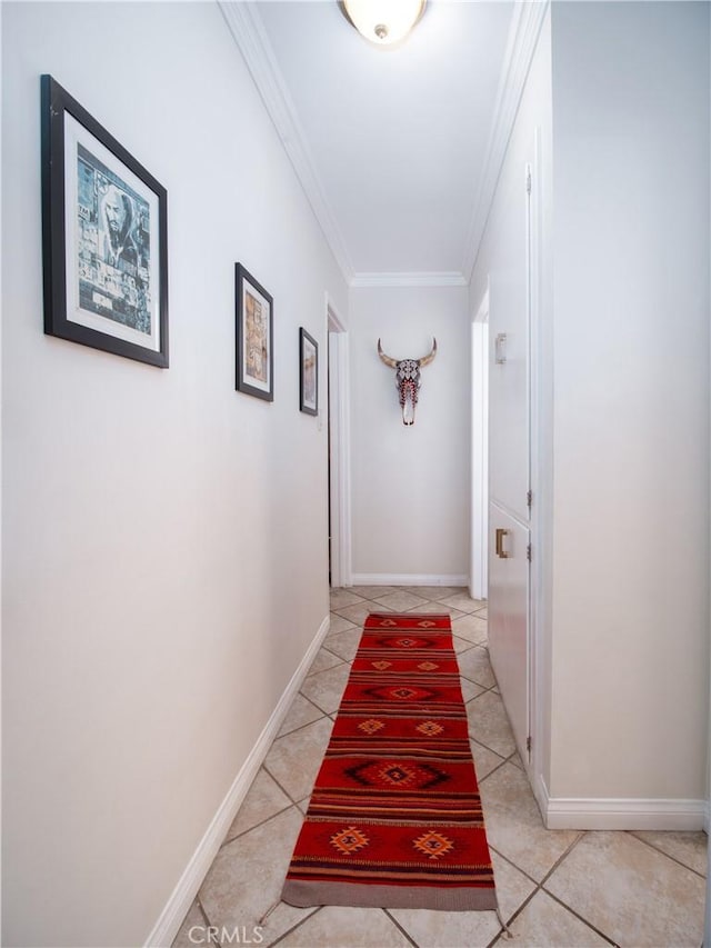 hallway featuring light tile patterned floors, ornamental molding, and baseboards