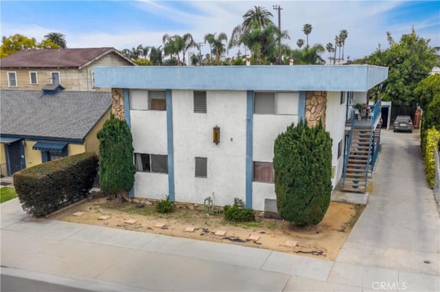 exterior space featuring stairs and stucco siding