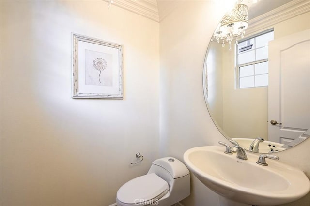 bathroom with a notable chandelier, a sink, and toilet