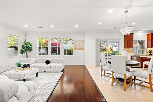 living room with recessed lighting, visible vents, baseboards, ornamental molding, and light wood finished floors