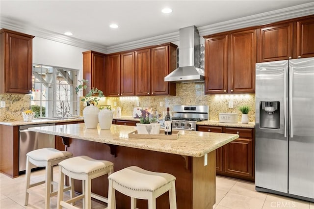 kitchen featuring light tile patterned floors, tasteful backsplash, wall chimney exhaust hood, a breakfast bar area, and stainless steel appliances