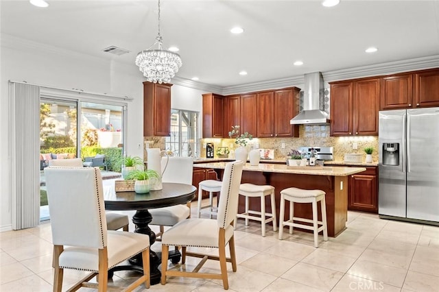 kitchen with ornamental molding, backsplash, wall chimney range hood, and stainless steel fridge with ice dispenser