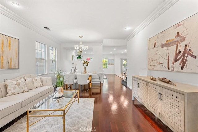 living area with crown molding, dark wood-style flooring, a healthy amount of sunlight, and a notable chandelier