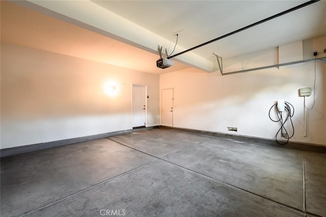 garage featuring a garage door opener and baseboards