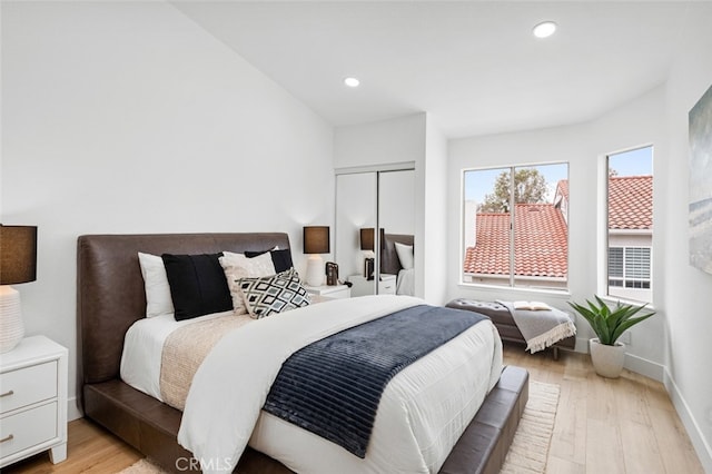 bedroom with light wood-type flooring, baseboards, and recessed lighting