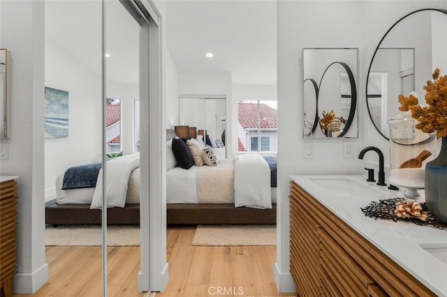 bedroom with a sink and light wood finished floors