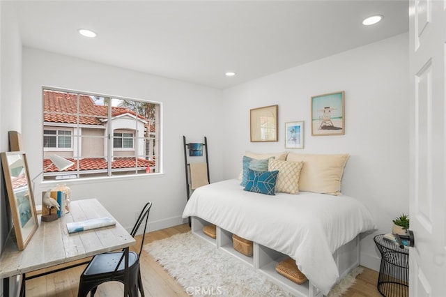 bedroom featuring baseboards, wood finished floors, and recessed lighting