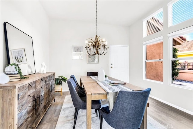 dining area with a notable chandelier, wood finished floors, and baseboards