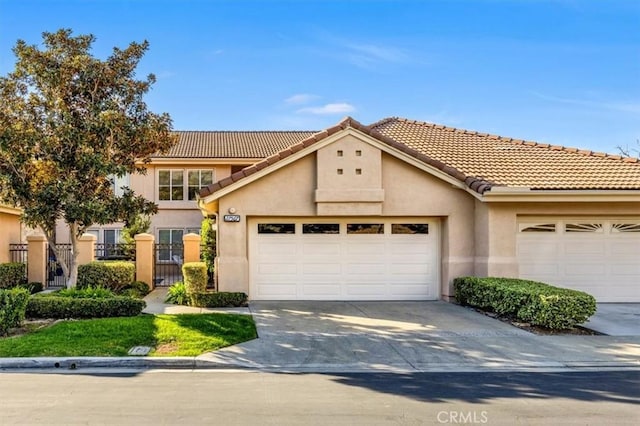 view of front of home with fence, stucco siding, concrete driveway, a garage, and a tiled roof