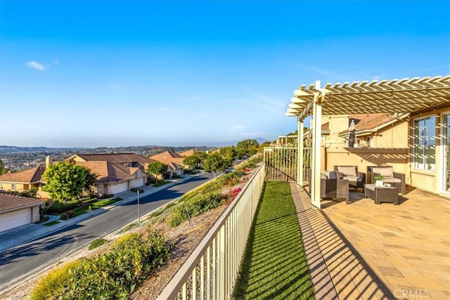 balcony with a residential view, an outdoor hangout area, and a pergola