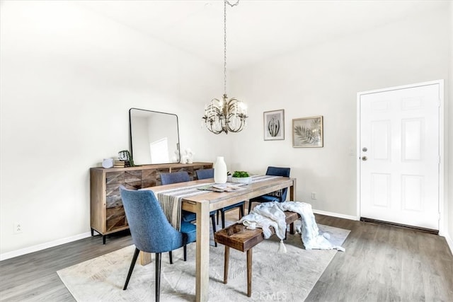 dining room featuring a notable chandelier, wood finished floors, and baseboards