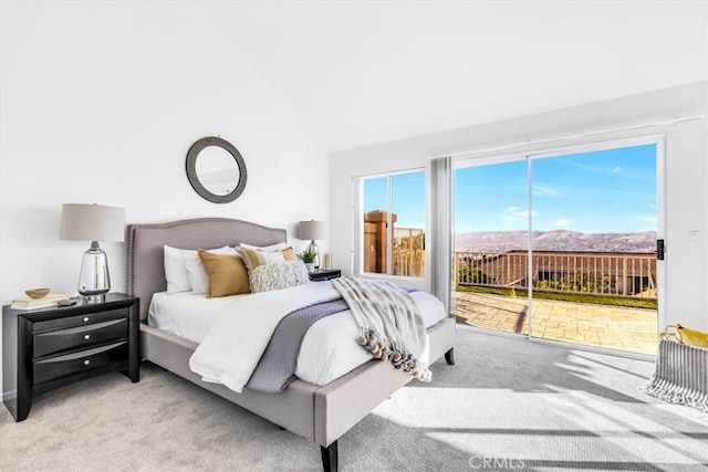 carpeted bedroom featuring access to exterior and vaulted ceiling