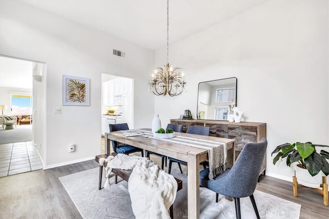 dining room with visible vents, baseboards, a notable chandelier, and wood finished floors