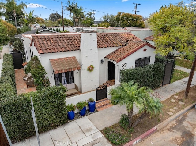 mediterranean / spanish home with a tiled roof and stucco siding