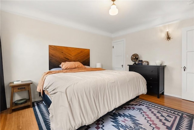 bedroom with baseboards and wood finished floors