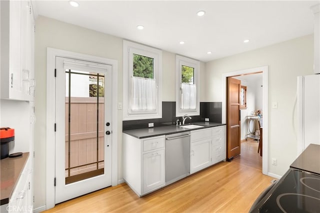 kitchen with light wood-style flooring, freestanding refrigerator, white cabinets, a sink, and dishwasher