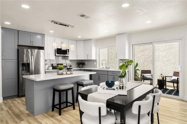 kitchen featuring stainless steel appliances, light countertops, and light wood finished floors