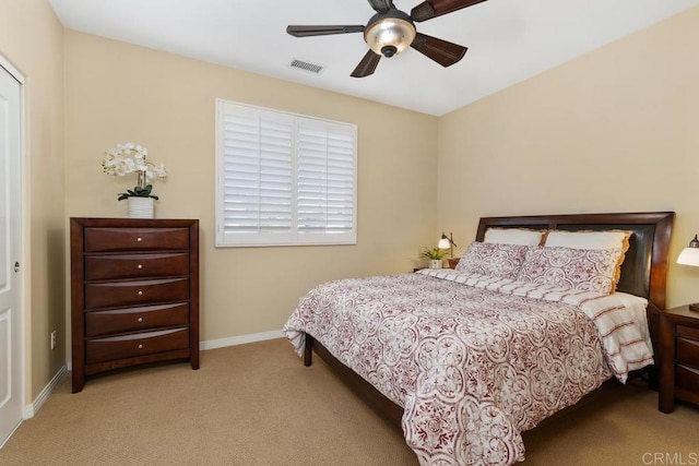 carpeted bedroom featuring a ceiling fan, visible vents, and baseboards