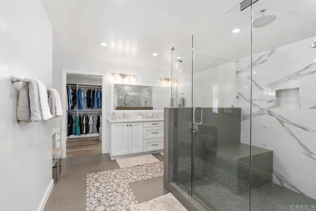 bathroom with recessed lighting, tile patterned flooring, a marble finish shower, and vanity