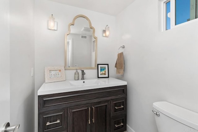 bathroom with toilet, visible vents, and vanity