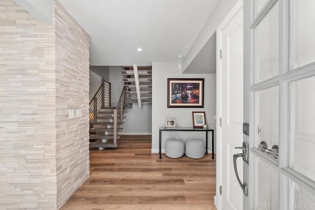 foyer entrance featuring light wood-style flooring, stairs, baseboards, and recessed lighting