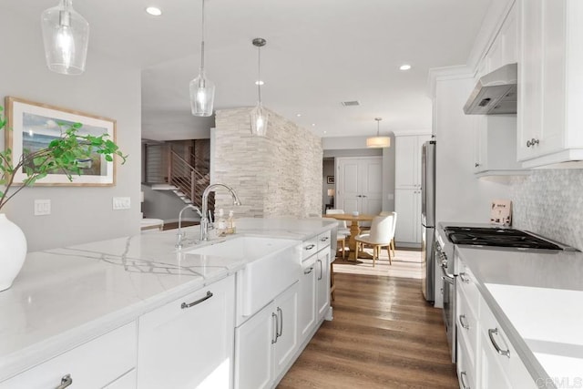 kitchen featuring decorative backsplash, appliances with stainless steel finishes, dark wood-type flooring, range hood, and white cabinetry