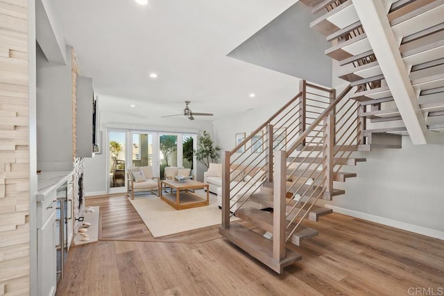 stairs with baseboards, wood finished floors, a ceiling fan, and recessed lighting