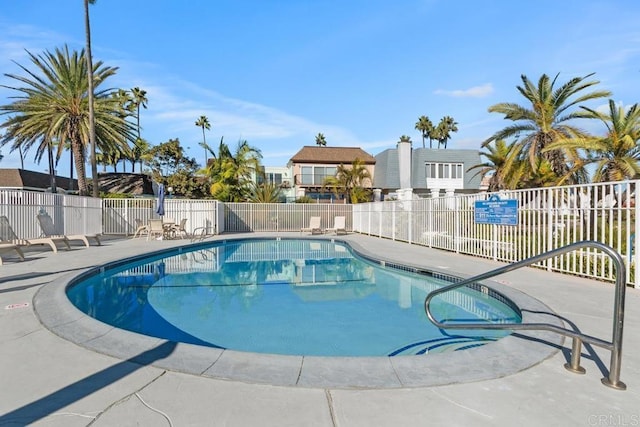 pool with a patio and fence