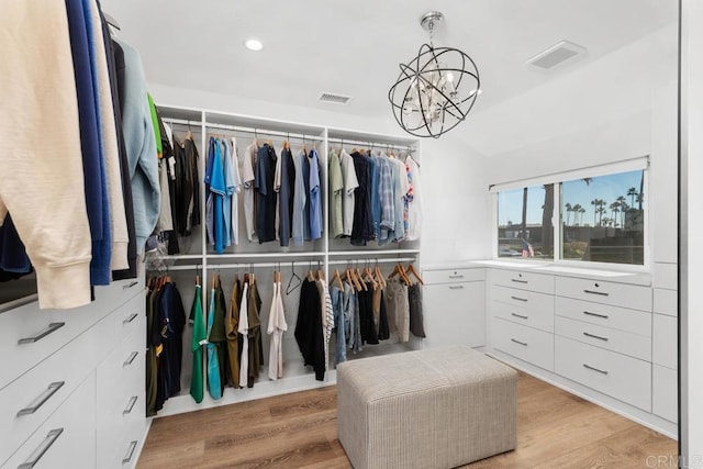 spacious closet featuring a chandelier, visible vents, and light wood-style flooring