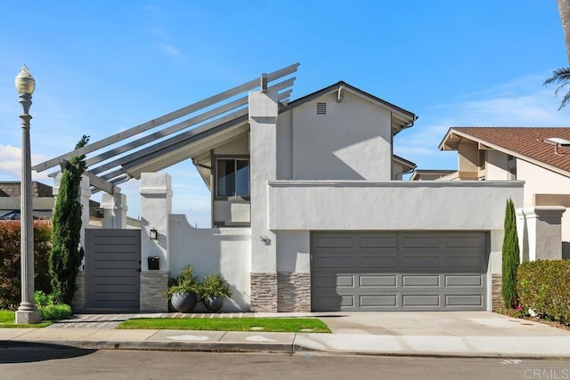 contemporary house with stone siding, driveway, and stucco siding