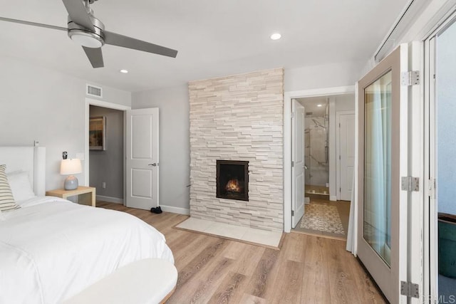 bedroom with ceiling fan, a stone fireplace, recessed lighting, visible vents, and light wood finished floors