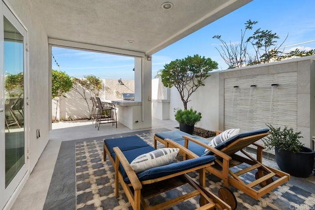 view of patio featuring outdoor dry bar, grilling area, and a fenced backyard