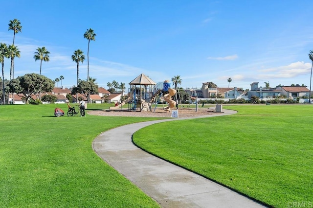 view of property's community featuring playground community and a lawn