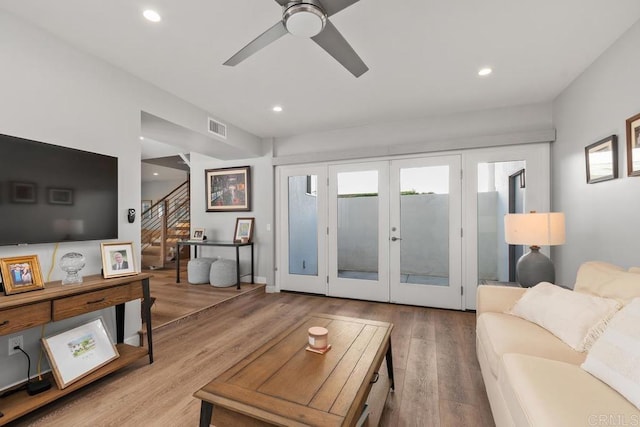 living room featuring recessed lighting, wood finished floors, visible vents, stairs, and french doors