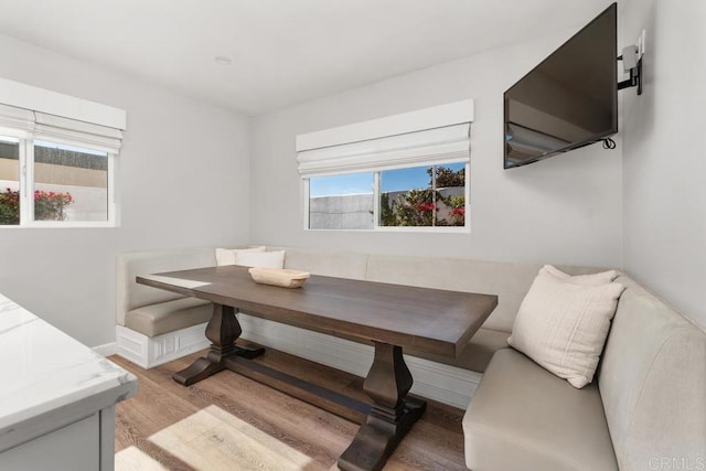 dining area with light wood finished floors, breakfast area, and baseboards