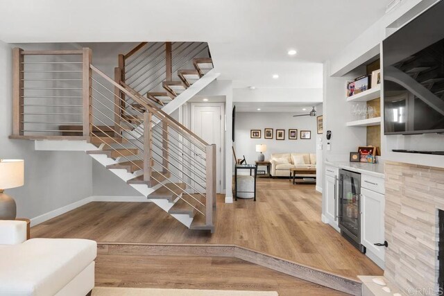 interior space with recessed lighting, beverage cooler, wood finished floors, baseboards, and a dry bar