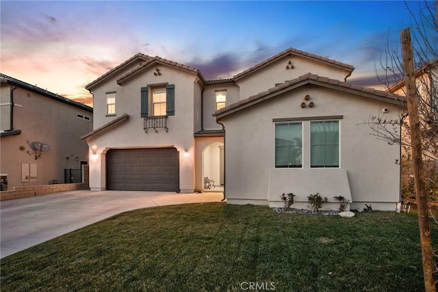 mediterranean / spanish-style house with an attached garage, driveway, a tiled roof, stucco siding, and a front yard