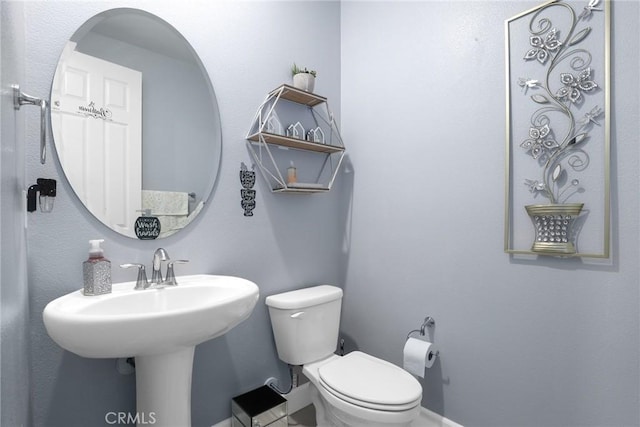 bathroom featuring baseboards and toilet