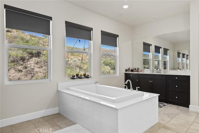 bathroom with recessed lighting, vanity, tile patterned flooring, baseboards, and a bath